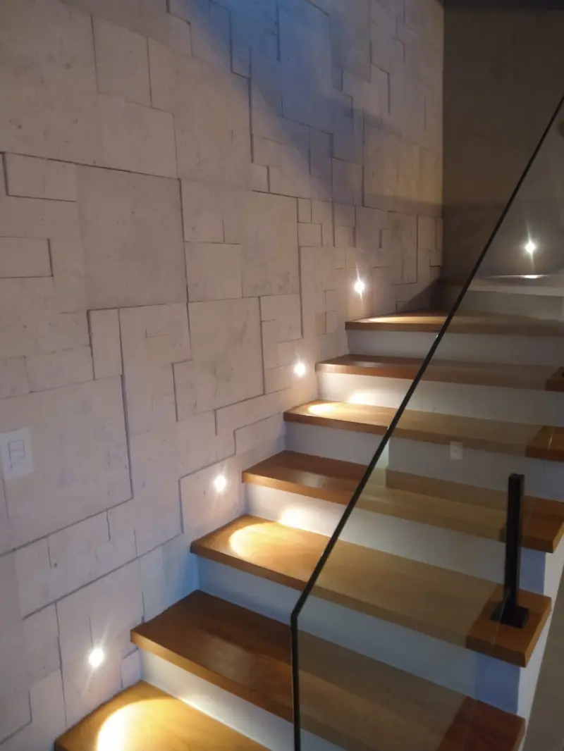 Escada com degraus de madeira e iluminação embutida