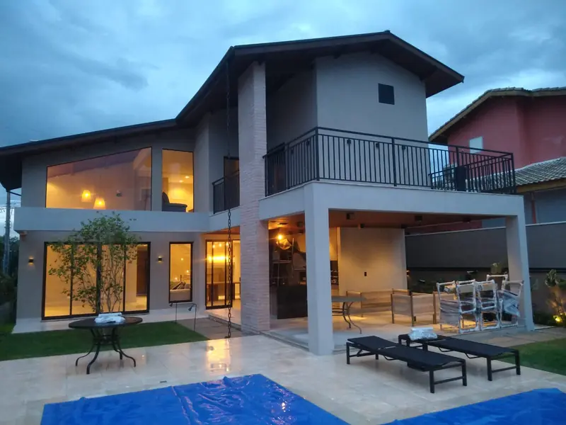 Casa iluminada ao entardecer com piscina