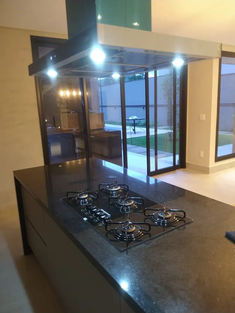 Ilha em granito com cooktop e coifa