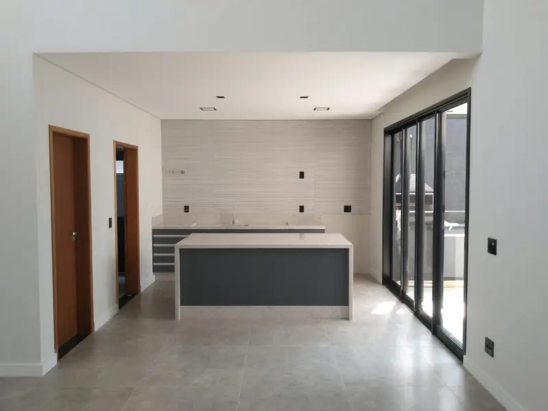 Cozinha integrada com ilha e portas de vidro