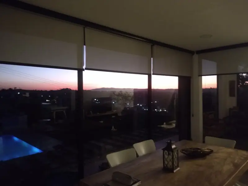 Sala com persianas e piscina iluminada