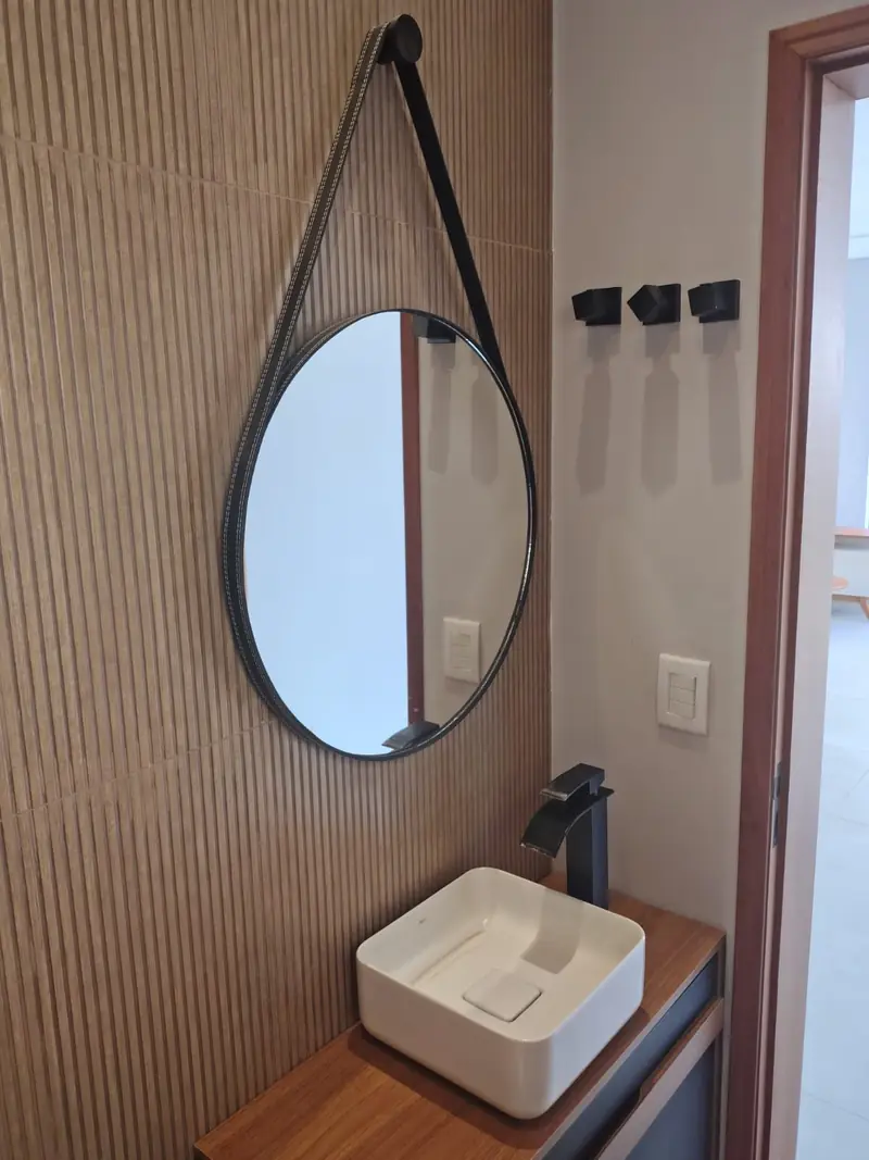 Lavabo com revestimento ripado e espelho redondo