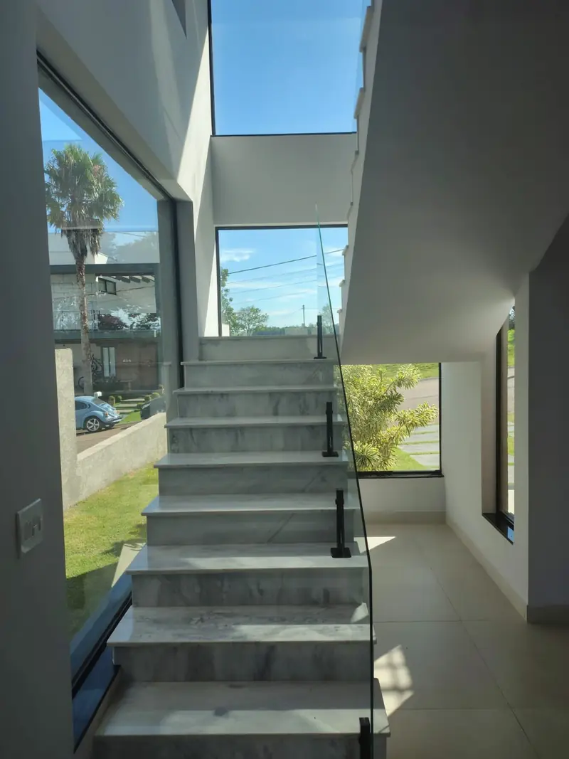 Escada em mármore com guarda-corpo de vidro