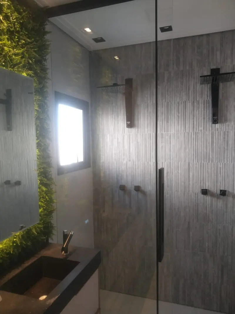 Banheiro com jardim vertical e duchas