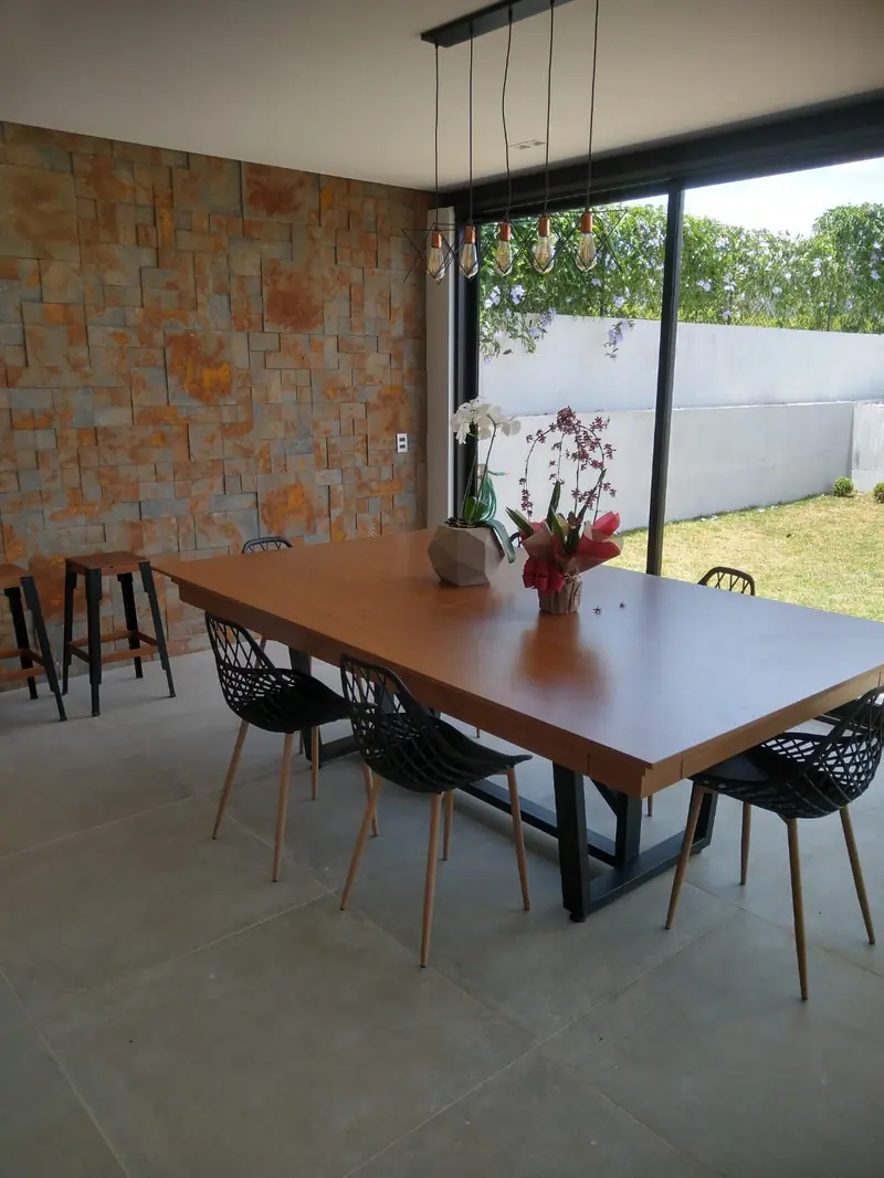 Mesa da área gourmet com parede em pedra