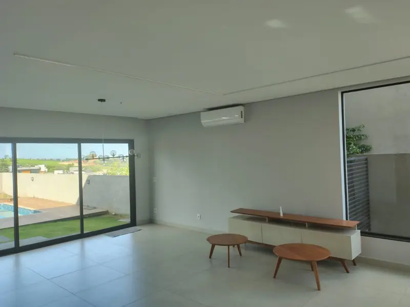 Sala de estar ampla com porta de vidro para o quintal