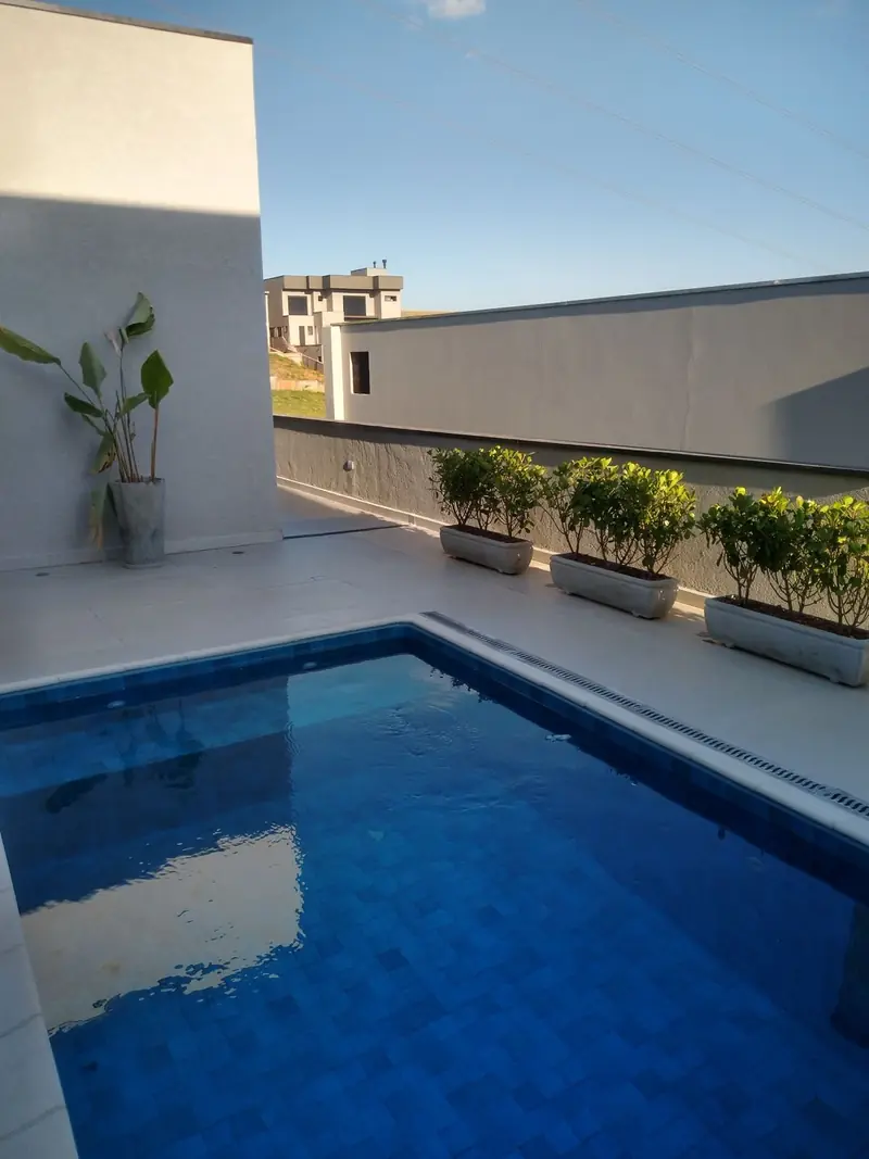Piscina com revestimento azul e floreiras