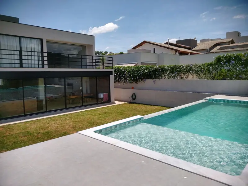 Casa de linhas retas com piscina de prainha e spa