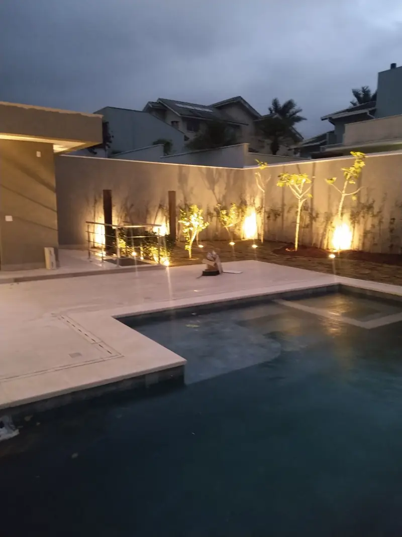 Piscina e jardim com iluminação noturna