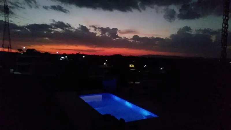 Piscina iluminada em azul ao pôr do sol