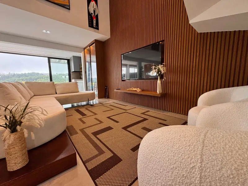 Sala de estar com painel ripado em madeira e sofá claro