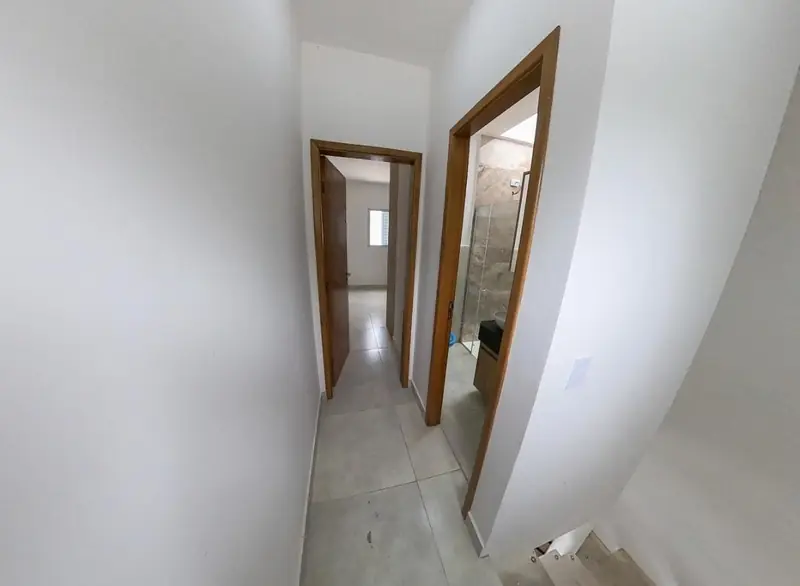 Corredor do pavimento superior com acesso ao quarto e ao banheiro