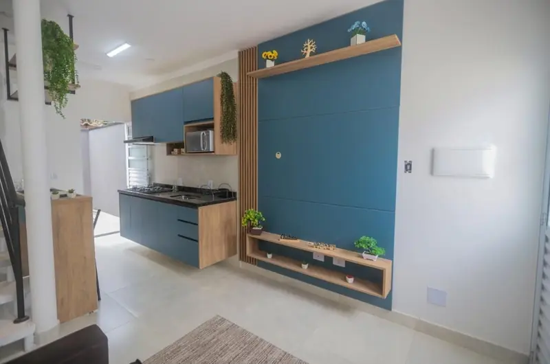 Cozinha planejada em azul e madeira integrada à sala