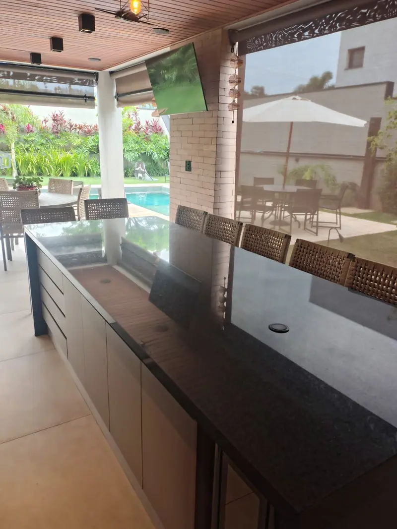 Bancada em granito da área gourmet com vista para a piscina
