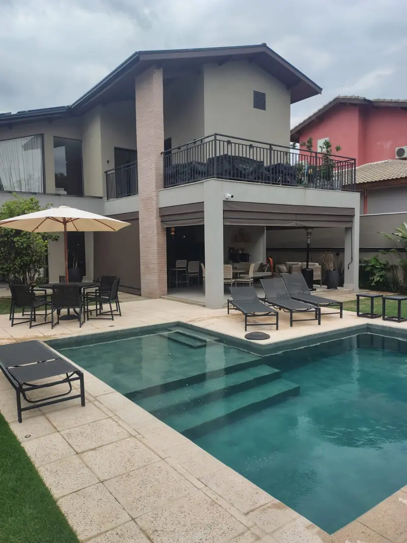 Casa de dois pavimentos com varanda gourmet, piscina e espreguiçadeiras