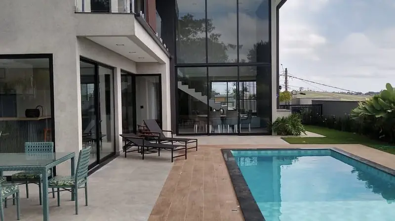 Deck, piscina e pano de vidro da casa